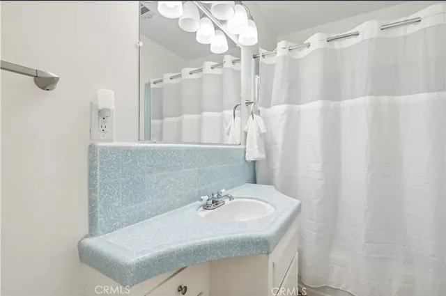 a bathroom with a sink vanity granite tub and shower
