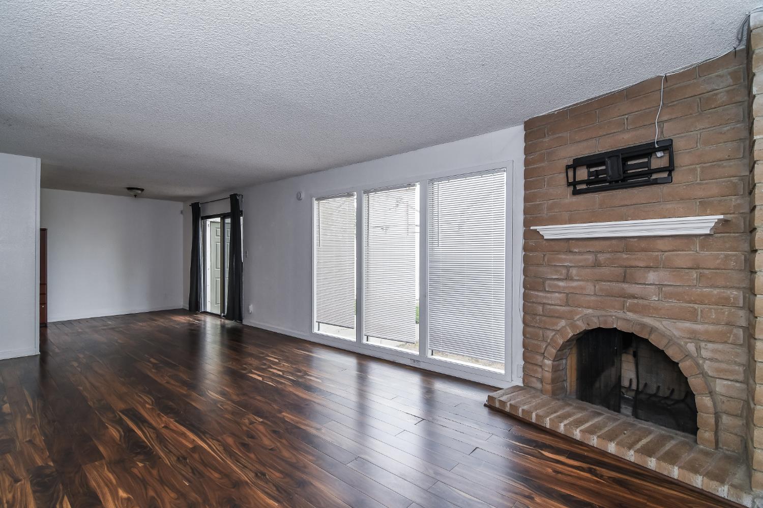 1139 Rivara Circle Sacramento, CA 95864 - Photo 12 of 72 a view of an empty room with wooden floor fireplace and a window