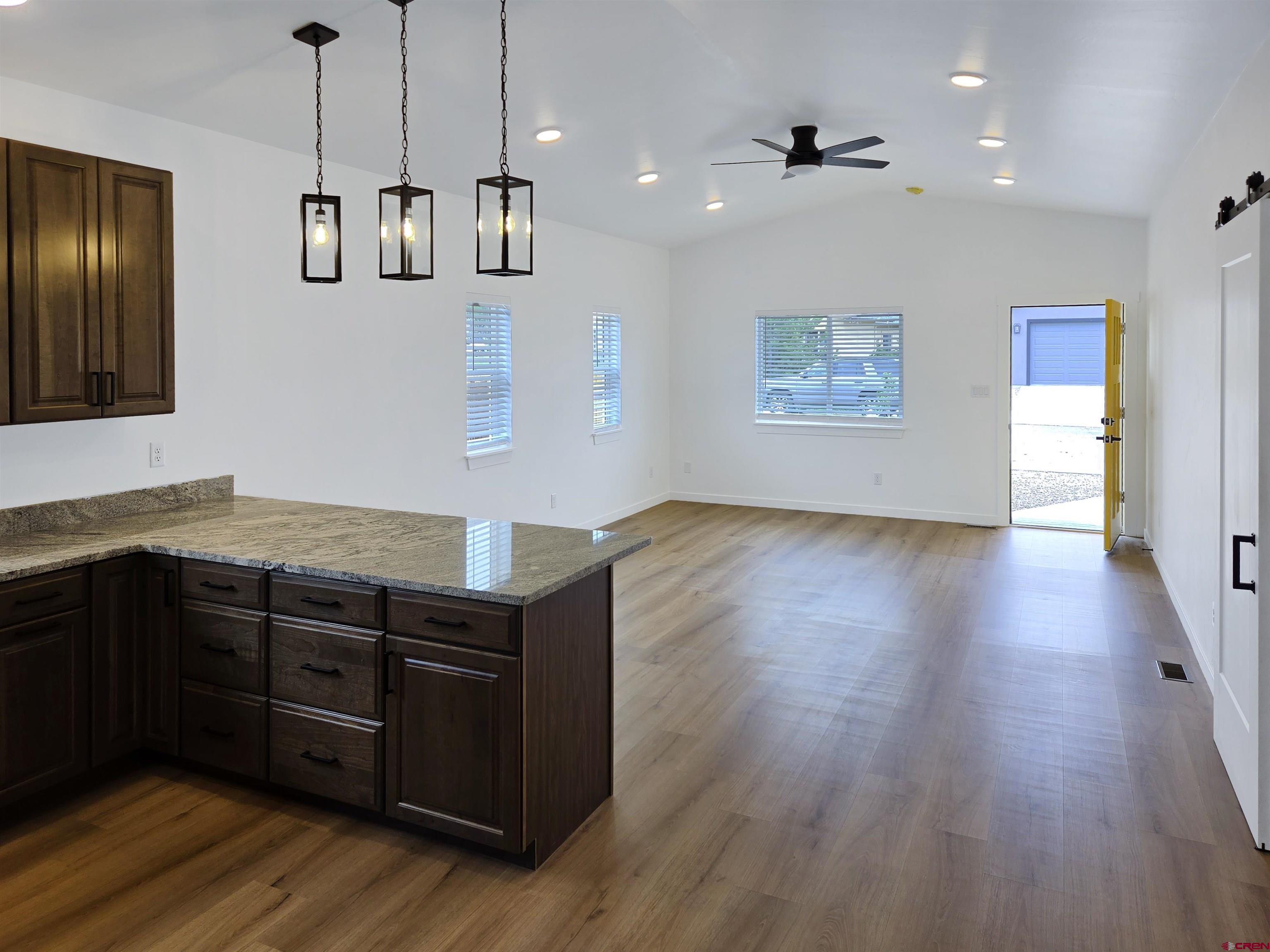 1456 Acoma Street Cortez, CO 81321 - Photo 8 of 26 a kitchen with stainless steel appliances granite countertop wooden floors and granite counter tops