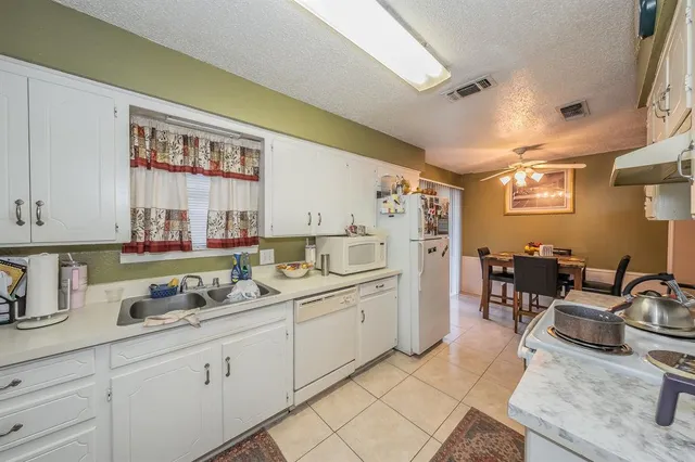 a kitchen with stainless steel appliances granite countertop sink window and cabinets