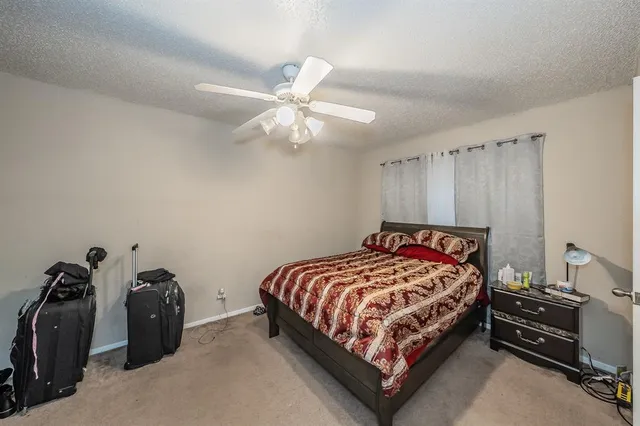 a bedroom with a bed and a ceiling fan
