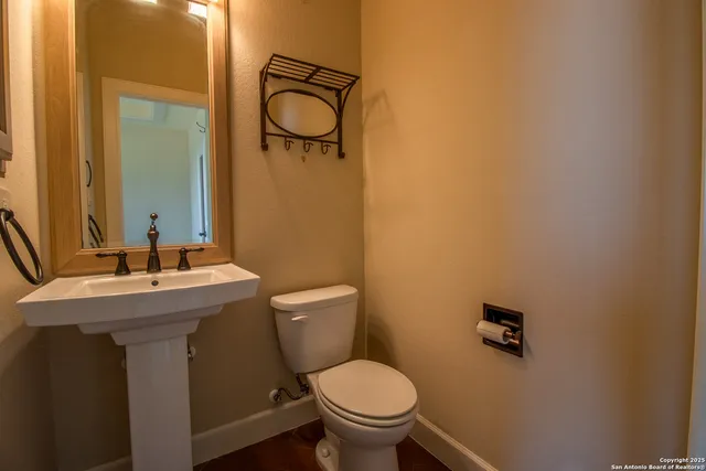 a bathroom with a toilet a sink and mirror