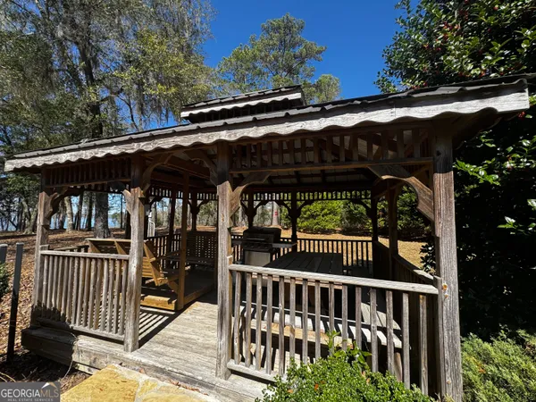 a view of porch with small trees and wooden fence