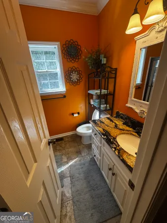 a bathroom with a granite countertop toilet sink and mirror