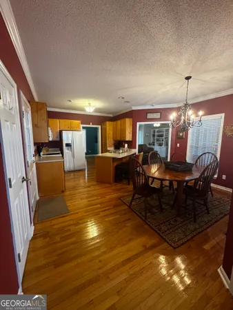 a living room with furniture a dining table and chairs with wooden floor