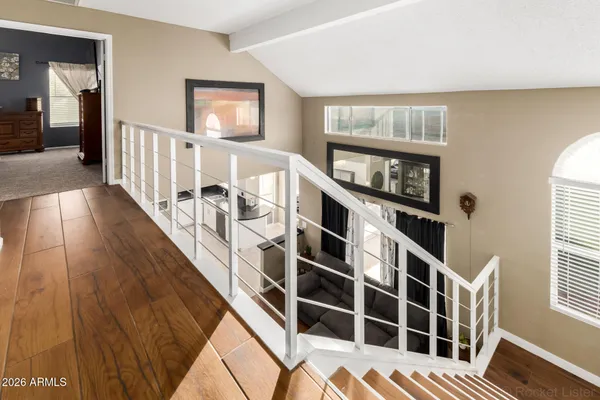 a view of a hallway with wooden floor and windows