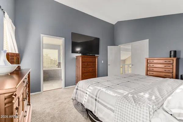 a bedroom with a bed and flat screen tv