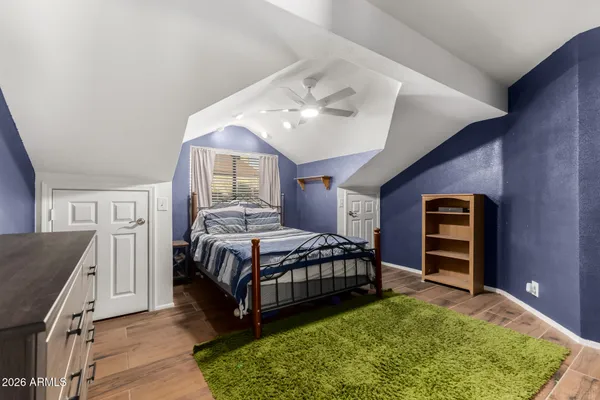 a spacious bedroom with a bed and a dresser