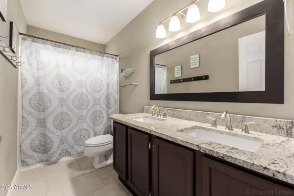 a bathroom with a granite countertop sink mirror vanity and toilet