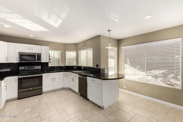 a large kitchen with stainless steel appliances granite countertop a stove and a sink