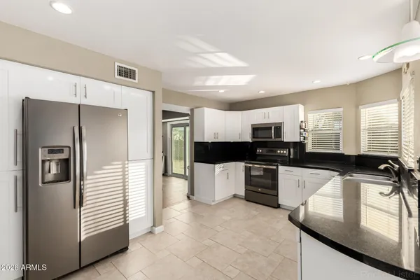 a kitchen with a refrigerator and a stove top oven
