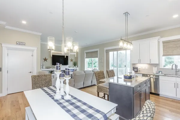 a view of a dining room and livingroom with furniture wooden floor a chandelier