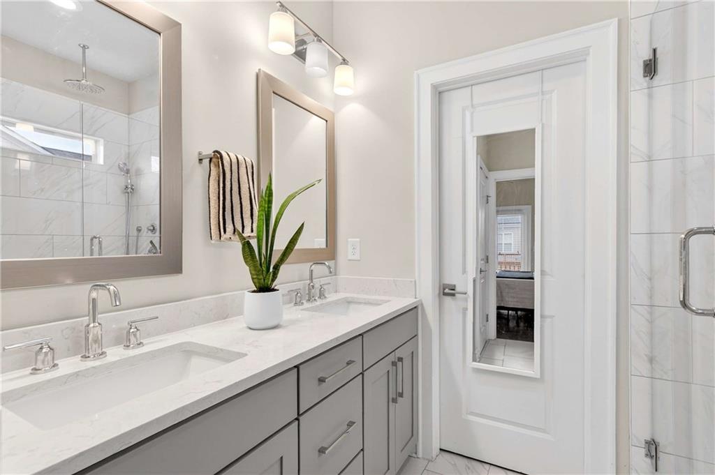 4302 Parkside Place Atlanta, GA 30342 - Photo 20 of 33 a bathroom with a sink a mirror and a shower