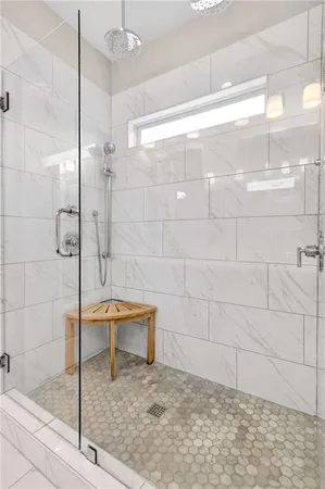 a spacious bathroom with a granite countertop sink a mirror a shower and a bathtub