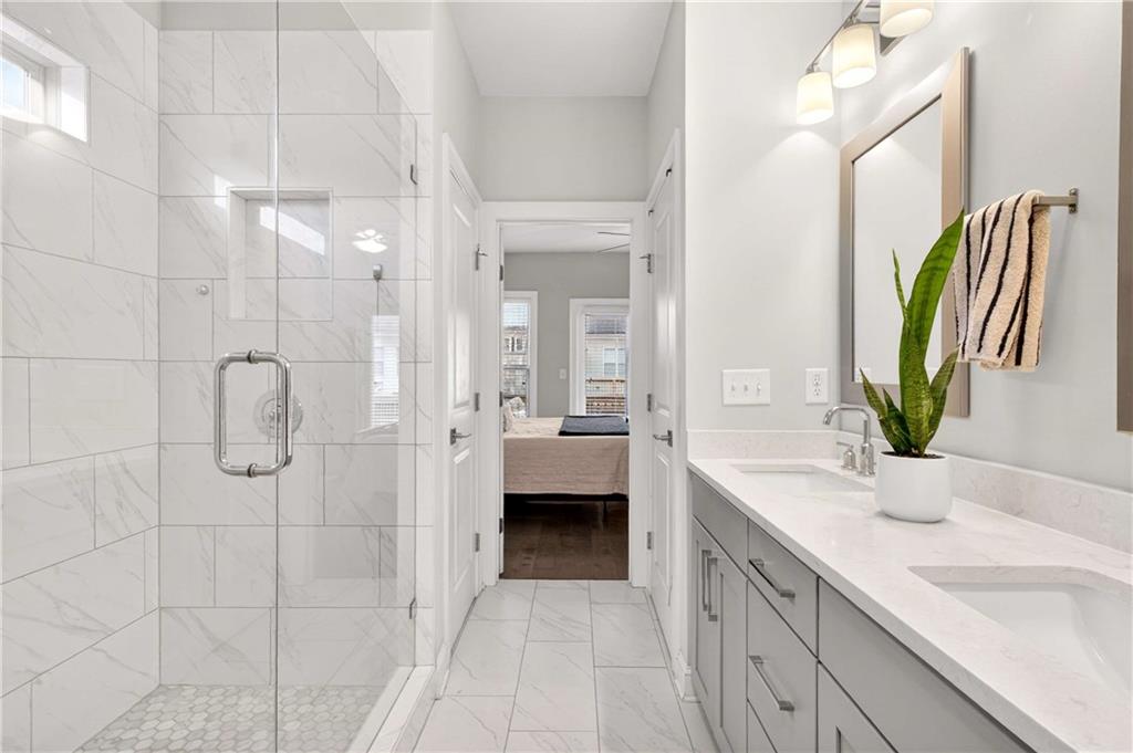 4302 Parkside Place Atlanta, GA 30342 - Photo 22 of 33 a spacious bathroom with a granite countertop sink a mirror a shower and a bathtub