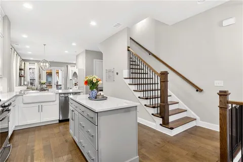 a kitchen with white cabinets appliances and center