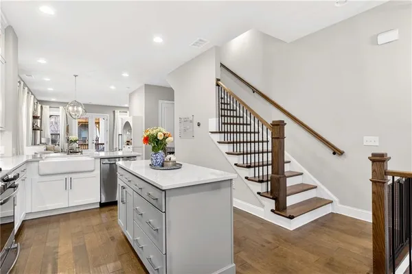 a kitchen with white cabinets appliances and center