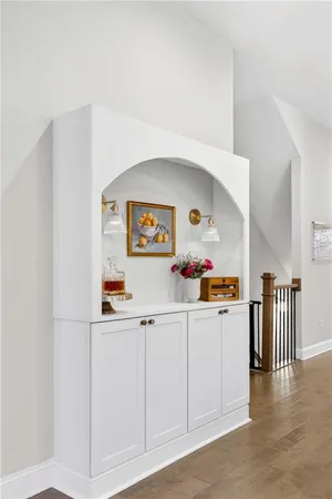 a kitchen with white cabinets and wooden floor