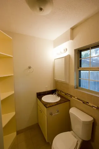 a bathroom with a toilet sink and mirror
