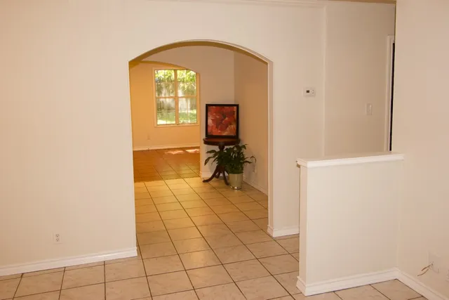 a view of a hallway with wooden floor and a bathroom