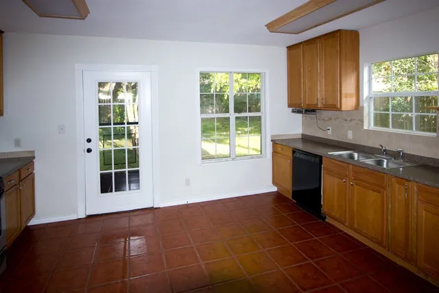 a kitchen with a sink a window and cabinets