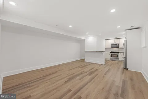 a kitchen with kitchen island white cabinets and stainless steel appliances