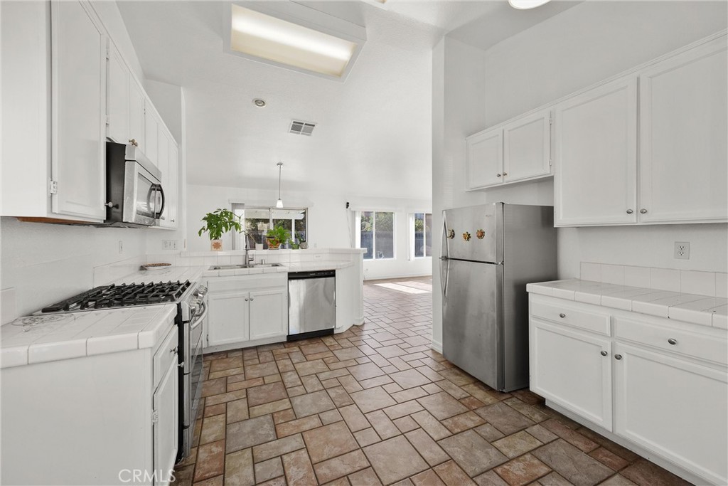 711 Myrtle Avenue Perris, CA 92571 - Photo 15 of 28 a kitchen with a stove a sink and a refrigerator