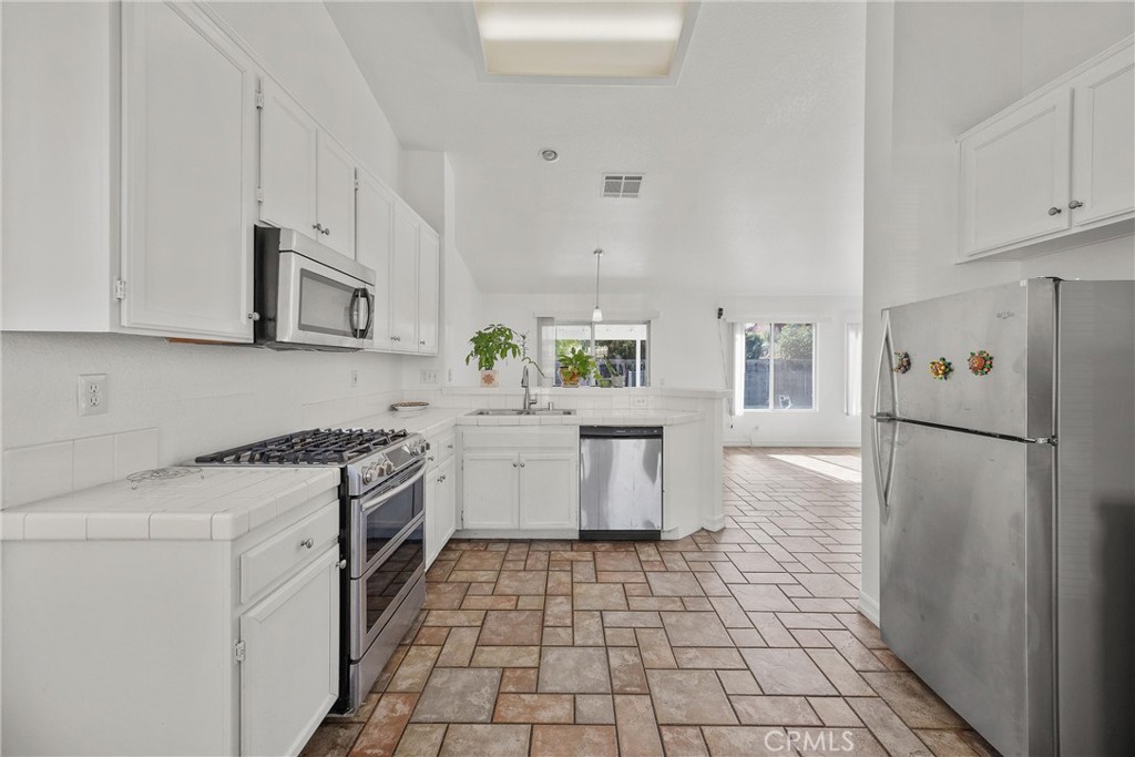 711 Myrtle Avenue Perris, CA 92571 - Photo 16 of 28 a kitchen with a stove a sink and a refrigerator