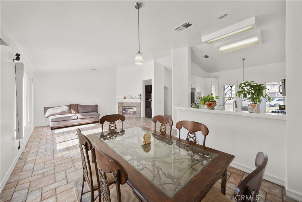 711 Myrtle Avenue Perris, CA 92571 - Photo 3 of 28 a view of a dining room and livingroom with furniture wooden floor a rug a fireplace and a chandelier