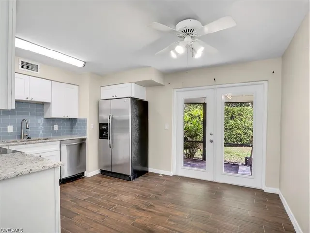 a view of a kitchen with a sink a refrigerator and a window