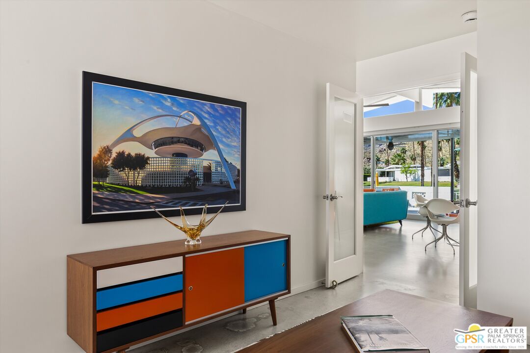 233 Toro Circle Palm Springs, CA 92264 - Photo 25 of 39 a living room with furniture a rug and a painting on the wall