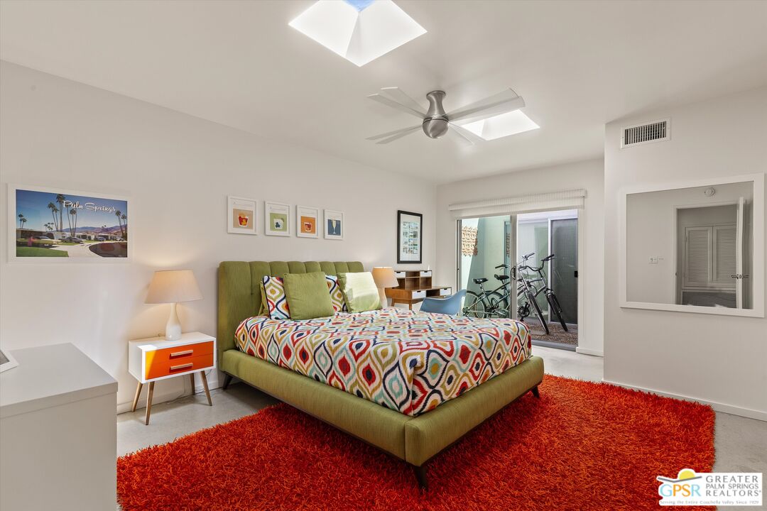 233 Toro Circle Palm Springs, CA 92264 - Photo 32 of 39 a bedroom with a bed lamp and a potted plant