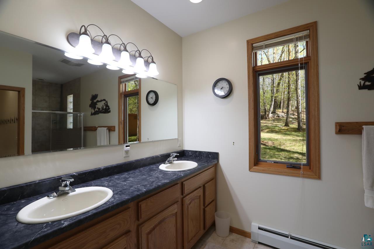 1880 Everett Bay Road Tower, MN 55790 - Photo 11 of 50 Full bath featuring a baseboard heating unit, healthy amount of natural light, a stall shower, and double vanity