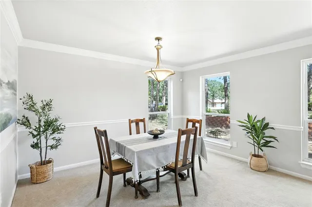a dining room with furniture potted plants and a chandelier