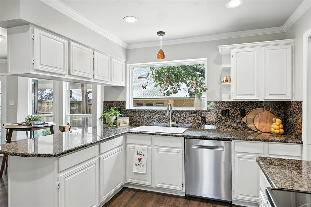 1330 Laredo Court Denton, TX 76205 - Photo 13 of 40 a kitchen with stainless steel appliances granite countertop white cabinets and window