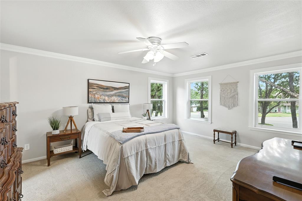 1330 Laredo Court Denton, TX 76205 - Photo 22 of 40 a bedroom with a bed and a chandelier