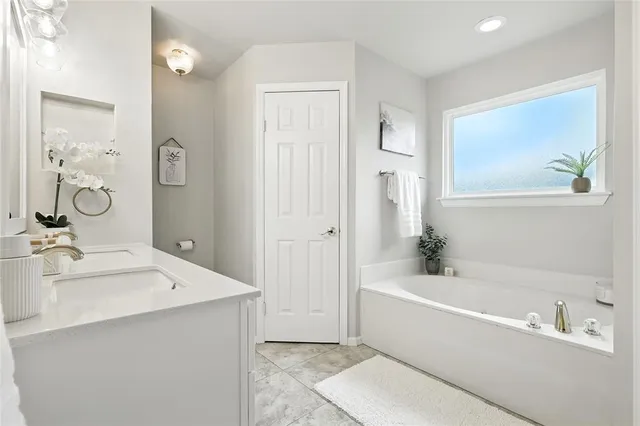 a bathroom with a bathtub a sink and a mirror