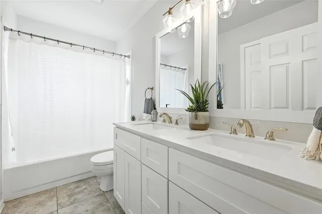 a bathroom with a granite countertop sink a toilet and a shower
