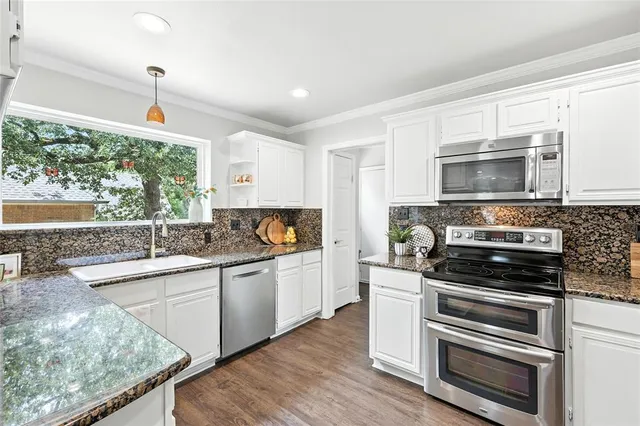 a kitchen with sink a microwave and cabinets