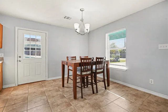 a view of a dining room with furniture and chandelier