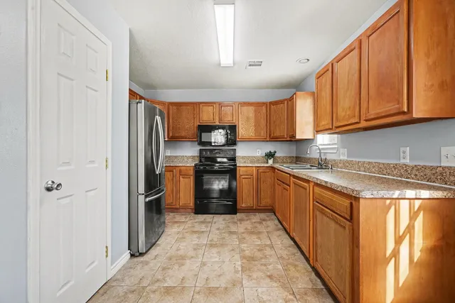 a kitchen with granite countertop a refrigerator and a sink