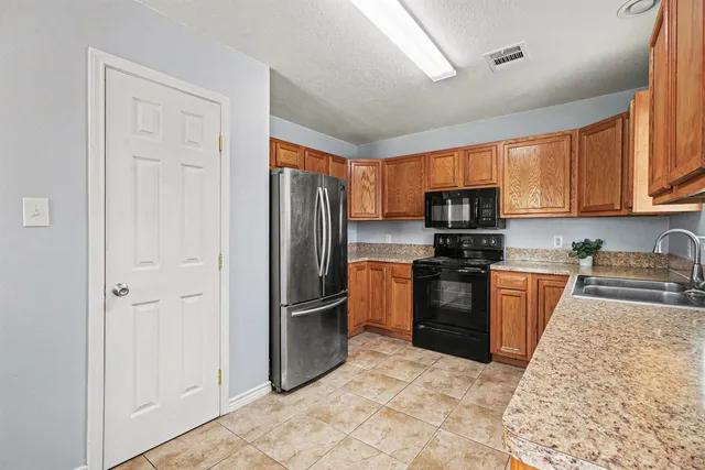 a kitchen with stainless steel appliances granite countertop a refrigerator stove and sink