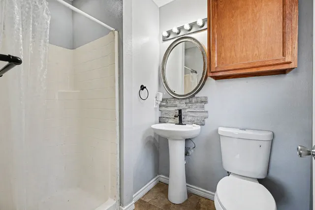 a bathroom with a toilet sink and mirror