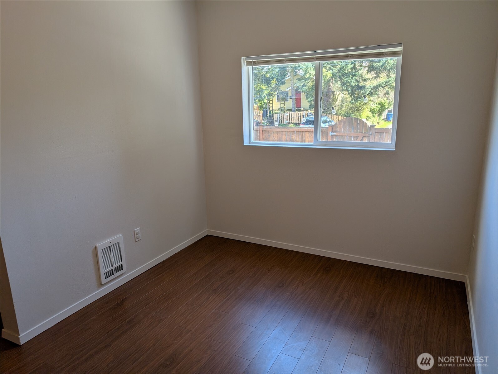 10341 Stone Avenue North Seattle, WA 98133 - Photo 12 of 18 an empty room with wooden floor and windows