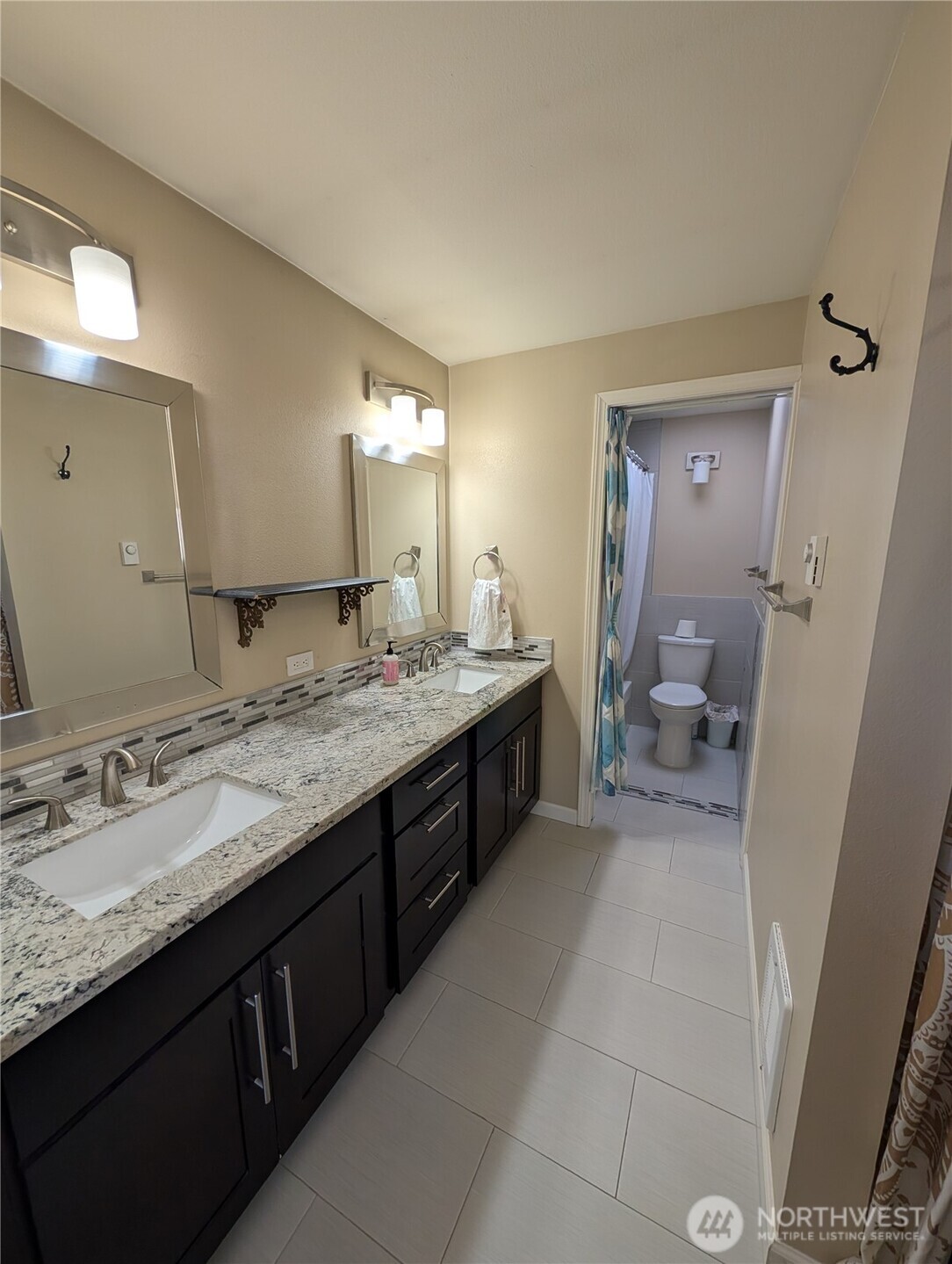 10341 Stone Avenue North Seattle, WA 98133 - Photo 4 of 18 a bathroom with a granite countertop double vanity sink and mirror
