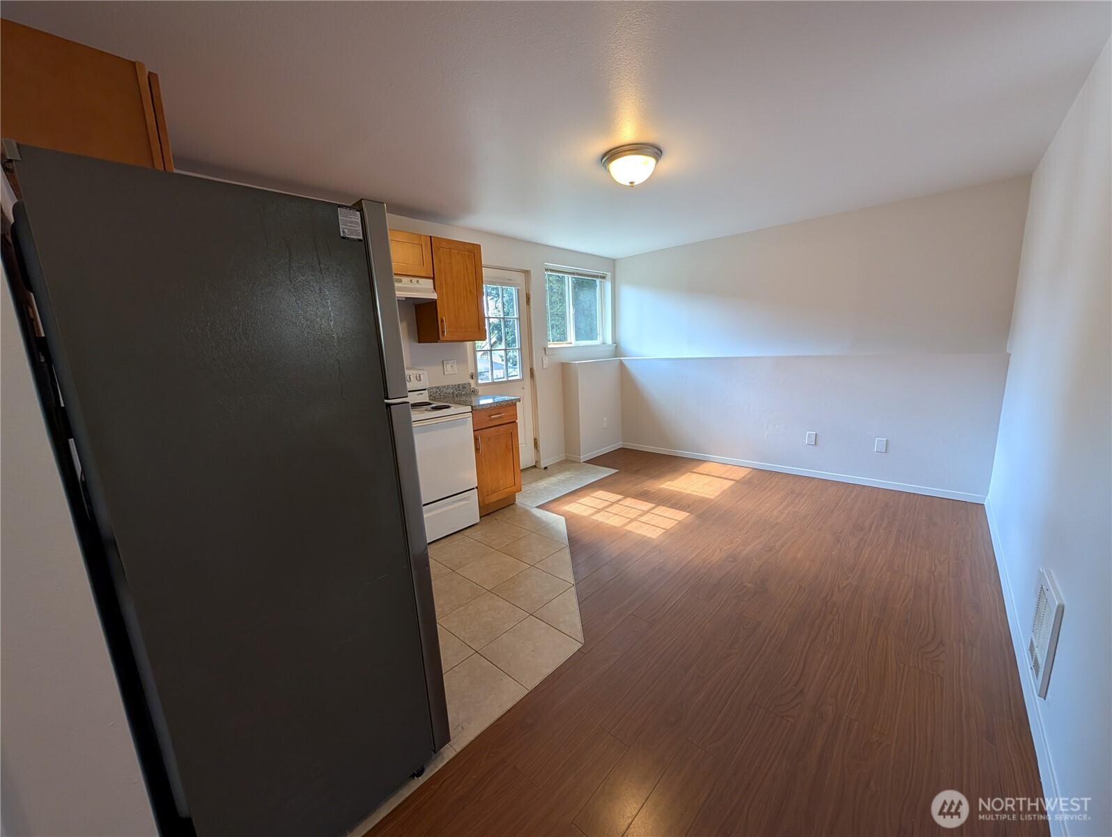10341 Stone Avenue North Seattle, WA 98133 - Photo 9 of 18 an empty room with chandelier fan and windows