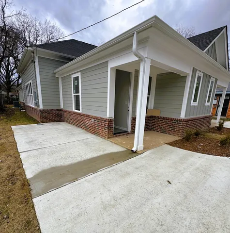 a view of house with backyard and parking space