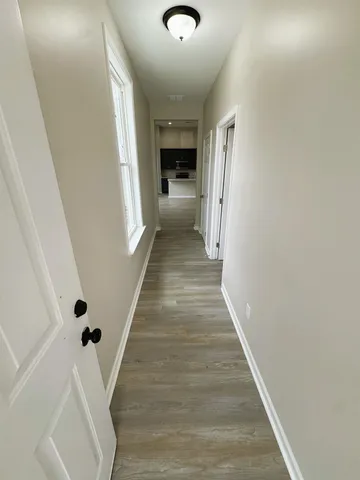 a view of a hallway with wooden floor and staircase
