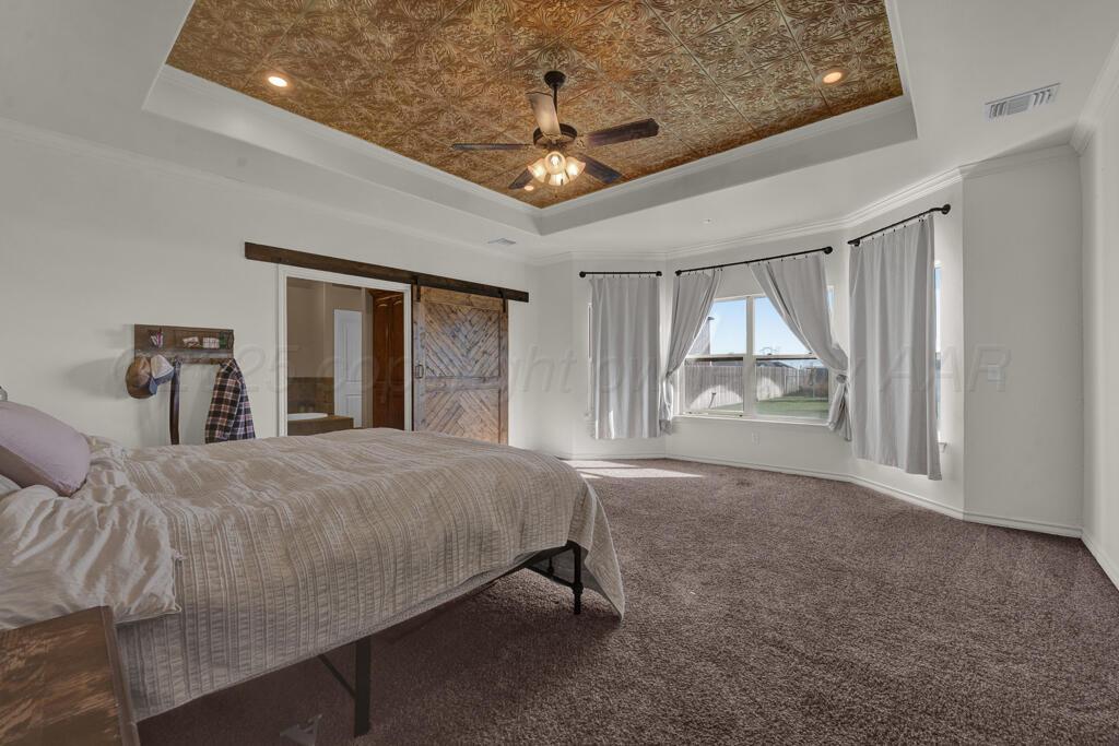 17801 Stone Creek Road Amarillo, TX 79124 - Photo 11 of 31 a bedroom with a large bed and a chandelier