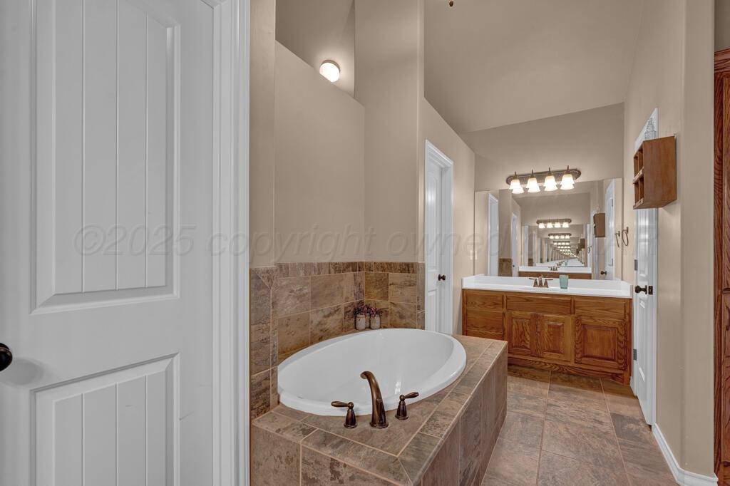 17801 Stone Creek Road Amarillo, TX 79124 - Photo 15 of 31 a bathroom with a tub a sink and a mirror